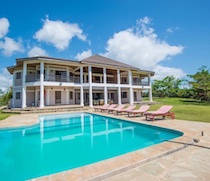 This spacious villa is located in large beachfront gardens on Galu Beach. White columns and sweeping verandas along the front and back of the house give it a very imposing appearance.

There are 7 double or twin bedrooms, 6 of which are en-suite. The towering centre of